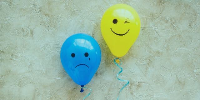 Gülümseyen depresyon, dışarıdan son derece mutlu görünürken iç dünyada derin bir acı çekme halidir. Öncelikle, bu durumu yaşayan kişiler genellikle işlerinde çok başarılı, sosyal ve enerjik görünürler. Çevrelerindeki insanlar onların mükemmel bir hayata sahip olduğunu düşünür. Oysa içsel olarak büyük bir boşluk, çaresizlik ve umutsuzlukla savaşırlar. Modern çağın en sinsi psikolojik sorunlarından biri olan bu durum, kişinin sessizce tükenmesine yol açar. Dolayısıyla, bu kusursuz maskenin ardındaki gerçeği anlamak, iyileşme sürecinin ilk ve en kritik adımıdır. Kusursuzluk Yanılgısı ve İçsel Çatışmalar Birçok insan, üzüntüsünü gizlemenin güçlü bir karakterin göstergesi olduğuna inanır. Bu yanlış inanç, kişinin kendi duygularını bastırmasına ve çevresine sürekli sahte bir neşe sunmasına yol açar. Sabahları büyük bir enerjiyle uyanmış gibi rol yapmak, aslında zihinsel enerjiyi hızla ve acımasızca tüketir. Geceleri ise herkes uyuduğunda ve yalnız kalındığında, o bastırılmış çökkünlük duygusu tüm ağırlığıyla geri döner. Kısacası, dışarıdaki o parlak vitrin ile içerideki harabe arasında devasa ve yorucu bir uçurum oluşur. Toplumun bizden sürekli pozitif olmamızı beklemesi bu durumu maalesef daha da zorlaştırır. Günümüzde başarılı olmak, sürekli gülümsemek ve asla şikayet etmemek modern bir zorunluluk gibi sunuluyor. Buna karşın, insan doğası gereği her zaman mutlu kalamaz ve zorluklar yaşayabilir. Sürekli sahte bir maske takmak, bireyin kendi öz benliğine tamamen yabancılaşmasına neden olur. Sonuç olarak, kişi başkalarını memnun ederken kendi ruhsal acısına bile saygı duymayı unutur. 🔗 İnceleyin: Mani Dönemi: İlkbaharda Artan Bipolar Belirtileri Sessiz Çığlık: Gülümseyen Depresyon Belirtileri Nelerdir? Peki, çevremizdeki insanlarda veya kendi içimizde gizlenen gülümseyen depresyon belirtileri nelerdir? İlk bakışta bu belirtileri fark etmek oldukça zordur çünkü kişi mükemmel bir oyuncuya dönüşmüştür. Ancak, ani iştah değişiklikleri, uyku düzenindeki ciddi bozulmalar ve gizli ağlama krizleri en yaygın işaretlerdir. Kişi, arkadaş toplantılarında grubun en neşelisi iken, eve döndüğünde aniden bitkin düşerek saatlerce yataktan çıkamayabilir. Ayrıca, sürekli bir suçluluk duygusu ve "hayatım çok iyi, neden böyle kötü hissediyorum?" karmaşası yaşanır. Bir diğer önemli belirti ise derin bir tükenmişlik hissine rağmen mükemmeliyetçilikten asla ödün vermemektir. Bu kişiler, işte, okulda veya ilişkilerinde hata yapmaktan inanılmaz derecede korkarlar. Eleştiriye karşı aşırı hassas hale gelirler fakat bunu ustalıkla ve gülümseyerek gizlerler. Dolayısıyla, çevreden gelen "sen her zaman çok güçlüsün" övgüleri, aslında onların omuzlarındaki en ağır yüktür. Zira bu etiket, çöküş yaşadıklarında yardım istemelerini tamamen engeller. 🔗 İnceleyin: Öfke Kontrolü ve Sağlıklı İfade Yolları: İçinizdeki Ateşi Söndürün Sosyal Medya ve Sahte Mutluluk Baskısı Dijital dünya, bu maskeleme davranışını besleyen en büyük ve tehlikeli kaynaklardan biridir. Sosyal medya platformlarında herkes sadece en mutlu anlarını, başarılarını ve kusursuz tatillerini paylaşır. Bu durum, bireyin "herkes çok mutlu, bu dünyada bir tek ben acı çekiyorum" yanılgısına düşmesine sebep olur. Filtrelenmiş ve kurgulanmış hayatlar, kişinin kendi gerçekliğiyle ve acısıyla yüzleşmesini sürekli geciktirir. Aslında, o kusursuz fotoğrafların ardında binlerce insan sessizce aynı yalnızlığı ve hüznü paylaşmaktadır. Bu sanal baskıdan kurtulmak için düzenli dijital detoks uygulamak harika bir başlangıçtır. Ekrana bakarak geçirilen süreyi kısıtlamak, bireyin kendi iç sesini dış etkenler olmadan duymasına olanak tanır. Kendinizi başkalarının sanal sahneleriyle kıyaslamayı bıraktığınızda, omuzlarınızdaki o devasa yükün hafiflediğini anında hissedeceksiniz. Özetle, sevdiklerinizle kuracağınız şeffaf ve gerçek bağlantılar, sanal dünyadaki yüzlerce beğeniden çok daha iyileştiricidir. Kimler Daha Fazla Risk Altında Bulunuyor? Görünmez bir yük taşıyan bu sinsi rahatsızlık, özellikle bazı belirli kişilik yapılarında daha sık ortaya çıkar. Mükemmeliyetçi, aşırı sorumluluk sahibi ve başkalarını memnun etmeye odaklı kişiler (people-pleaser) en büyük risk grubundadır. Bu bireyler, başkalarının dertlerini çözmek için kendi fiziksel ve ruhsal ihtiyaçlarını tamamen yok sayarlar. Kendilerini daima ikinci plana atarak, sevginin ve değerin sadece "sorunsuz" olduklarında geleceğine inanırlar. Dolayısıyla, en ufak bir zayıflık göstermek onlar için büyük bir yenilgi anlamı taşır. Ayrıca, yüksek statülü meslek sahiplerinde, yöneticilerde ve tanınmış kişilerde de bu duruma sıkça rastlarız. Toplumun onlara biçtiği "her koşulda güçlü ve yenilmez" rolü, bir süre sonra nefes alınamayan bir hapishaneye dönüşür. Çevrelerinden yardım istemek, kariyerlerine veya imajlarına zarar verecek bir zayıflık olarak algılanır. Buna karşın, duyguları bastırmak onları asla yok etmez; aksine iç dünyada daha derin ve tehlikeli bir şekilde büyütür. 🔗 İnceleyin: Bahar Depresyonu Nedenleri ve Çözüm Yolları Maskeyi Düşürmek: Gülümseyen Depresyon Nasıl Tedavi Edilir? Hepimizin yanıtını aradığı o hayati soruya gelelim: Gülümseyen depresyon nasıl tedavi edilir? İlk ve açıkçası en cesur adım, ortada bir sorun olduğunu kabul etmek ve profesyonel yardım istemekten korkmamaktır. Bu rahatsızlık, klasik majör depresyon gibi tamamen tıbbi bir durumdur ve doğru uzman yaklaşımlarıyla aşılabilir. Uzman bir klinik psikolog eşliğinde yürütülen konuşma terapileri, bastırılmış tüm duyguların güvenli bir ortamda açığa çıkmasını sağlar. Böylece, kişi her an mükemmel olmak zorunda olmadığı gerçeğiyle nazikçe yüzleşir. Bilişsel Davranışçı Terapi (BDT) ve Kabul ve Kararlılık Terapisi (ACT), bu yüzleşme sürecinde oldukça etkilidir. Terapistinizle birlikte, sizi o sahte maskeyi takmaya zorlayan kök inançları ve travmaları keşfedersiniz. Ayrıca, semptomlar çok ağırsa psikiyatrist hekimlerin reçete edeceği antidepresanlar, beynin kimyasal dengesini yeniden kurmaya yardımcı olur. Doğru planlanmış ilaç ve terapi kombinasyonu, bu karanlık tünelden çıkışın en güvenli, en kalıcı yoludur. Terapi Odasında Kırılganlığa İzin Vermek Terapi süreci, kişinin hayatında belki de ilk defa tamamen maskesiz ve kendi olabildiği tek yerdir. Terapi odasında sizi yargılayan, sizden sürekli olağanüstü başarı ve neşe bekleyen kimse yoktur. Sadece anlaşıldığınızı, olduğunuz gibi kabul gördüğünüzü hissetmek bile iyileşme yolculuğunun yarısıdır. Kırılganlığınızı ve acınızı kucaklamak, sandığınızın aksine bir zayıflık değil, muazzam bir cesaret örneğidir. Zamanla, gerçek hislerinizi filtrelemeden ifade etmenin o büyük özgürlüğünü tadarsınız. Bununla birlikte, tedavi sürecinde stres yönetimi için uygulanan bazı ek tamamlayıcı yöntemler konusunda da dikkatli olmak gerekir. Yoga, meditasyon, nefes egzersizleri veya farkındalık (mindfulness) çalışmaları iyileşme sürecini harika bir şekilde destekler. Ancak, bu yaklaşımlar bireysel olarak değil, uzman bir hekim kontrolünde ve yönlendirilmesiyle uygulanmalıdır. Psikolojik destek çalışmaları yalnızca alanında uzmanlaşmış klinik psikologlar tarafından yürütülmeli, fizyolojik yöntemler ise ilgili sağlık profesyonellerinin önerileri doğrultusunda değerlendirilmelidir. Sonuç olarak, sizi yoran o ağır maskeyi sonsuza dek çıkarmak ve gerçek hislerinizle barışmak özgürleşmenin tek yoludur. Kendinize şefkat gösterin, çünkü mutluluk rolü yapmak yerine gerçekten huzurlu hissetmeyi sonuna kadar hak ediyorsunuz. Akademik Kaynaklar ve İleri Okuma İçerikte yer alan klinik bilgileri daha detaylı incelemek ve bilimsel dayanaklarını görmek için aşağıdaki uluslararası saygın kaynaklara göz atabilirsiniz: Masked Depression: A Diagnostic and Therapeutic Challenge - Modestin, J. (2011). Maskeli depresyonun klinik görünümü ve teşhis zorlukları üzerine detaylı bir inceleme. Atypical Depression in the 21st Century: Diagnostic and Treatment Issues - Thase, M. E. (2009). The American Journal of Psychiatry. Atipik depresyon özelliklerinin (dışarıdan iyi görünme hali) analizi. Clinical Practice Guideline for the Treatment of Depression Across Three Age Cohorts - American Psychological Association (APA) (2019). Yetişkinlerde depresyon çeşitleri ve güncel psikoterapi yönergeleri.