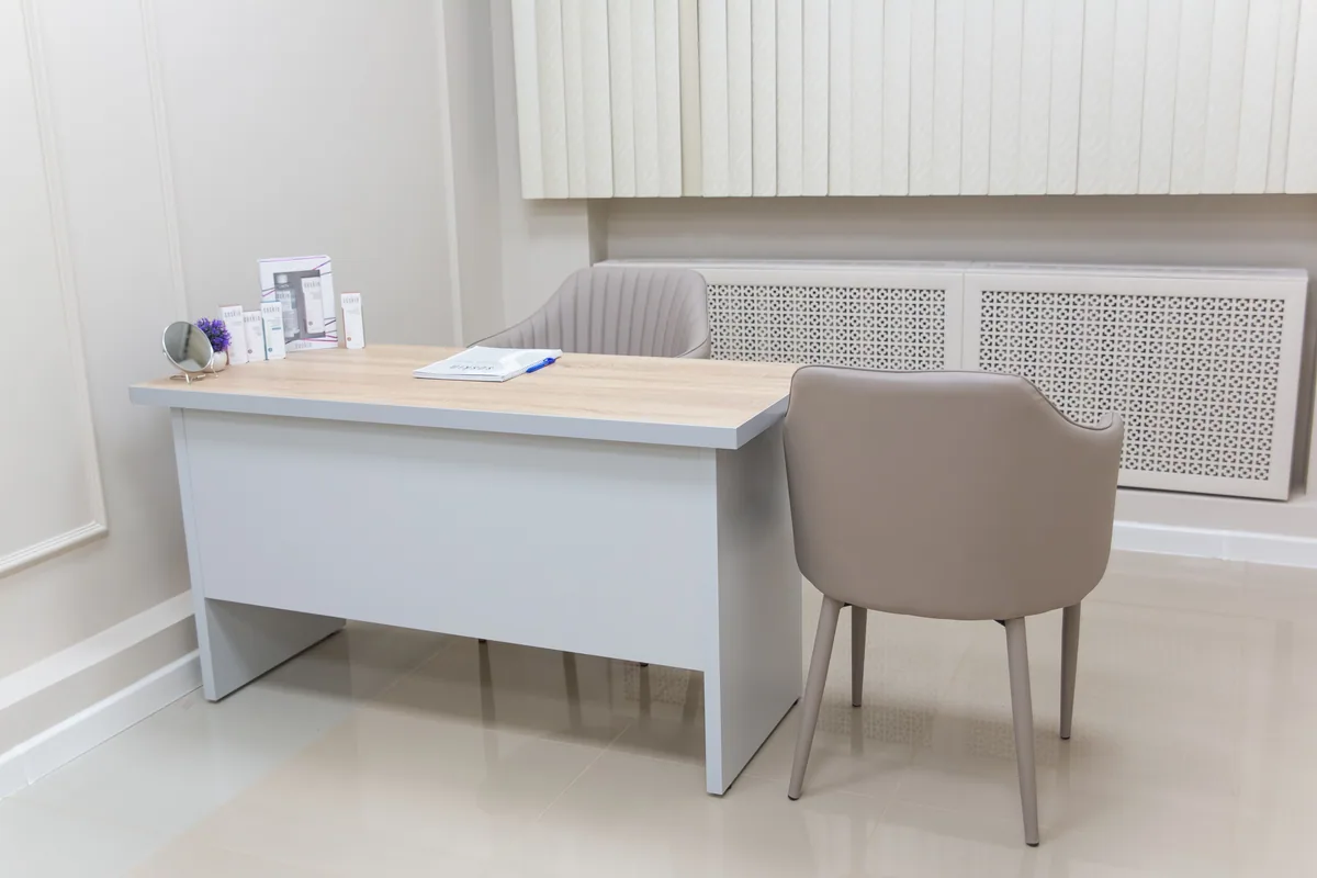 Psikolojik görüşme için iki koltuk ve masa bulunan aydınlık ofis